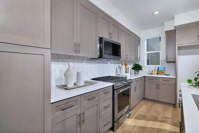 a kitchen with white cabinets and appliances
