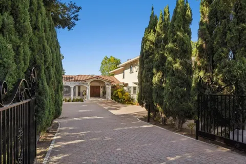 a front view of a house with a yard and tree s