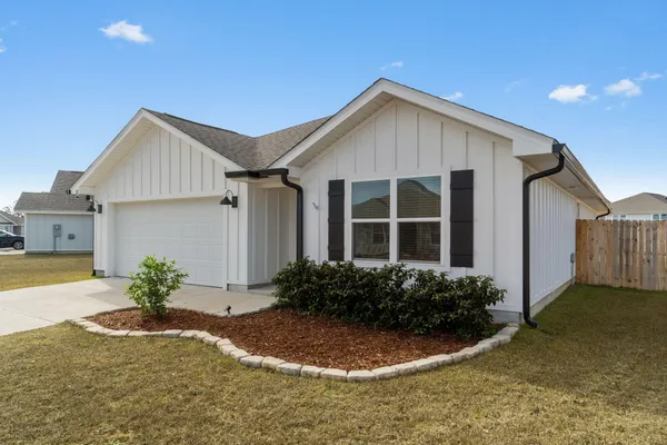 a view of a house with backyard and plants