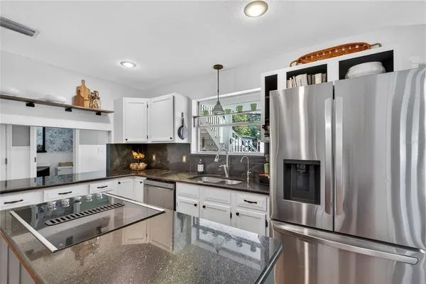 a kitchen with white cabinets and black appliances