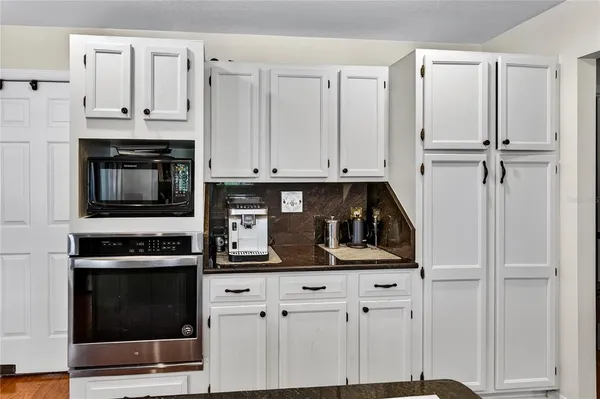 a kitchen with stainless steel appliances granite countertop a refrigerator stove and sink