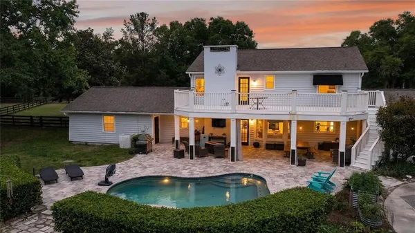a view of an house with a big yard and palm trees