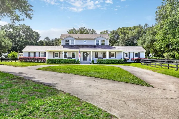 a front view of a house with a yard and potted plants