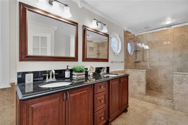 a bathroom with double vanity and a mirror