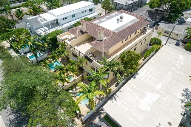 a living room with furniture large windows and wooden floor