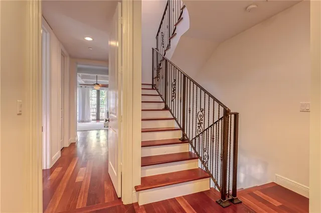 a bedroom with a large bed and a chandelier fan