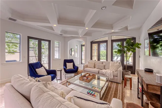 a bedroom with a bed couches and a flat tv screen