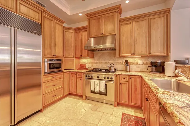 a bedroom with a large bed a chandelier and windows