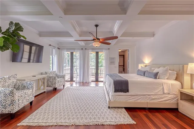 a spacious bedroom with two beds a chandelier and a window