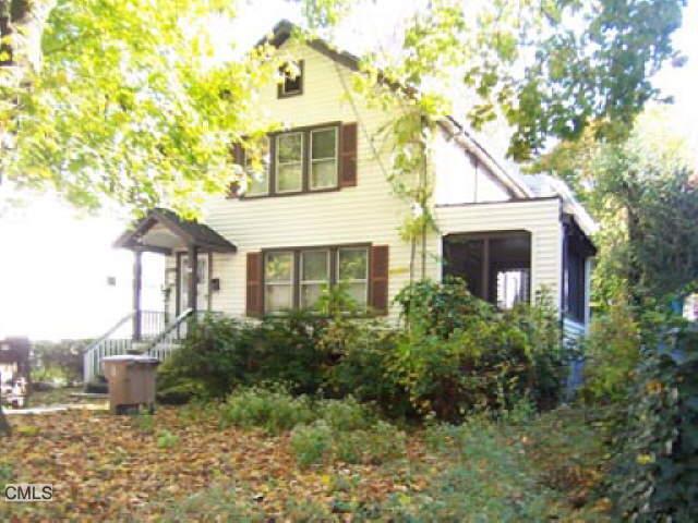 a front view of a house with plants and trees