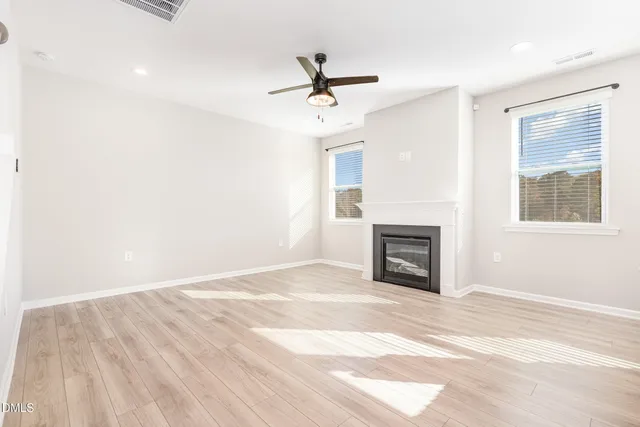 a view of an empty room with a fireplace and a window