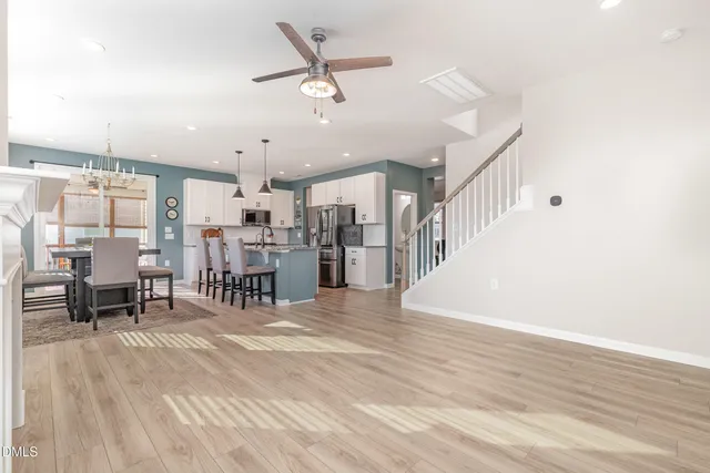 a view of a living room and kitchen with furniture wooden floor and a rug