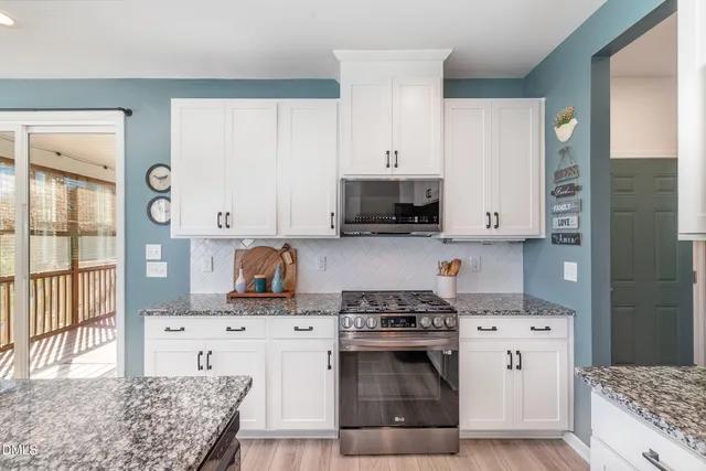 a kitchen with stainless steel appliances kitchen island granite countertop a stove a sink and a refrigerator