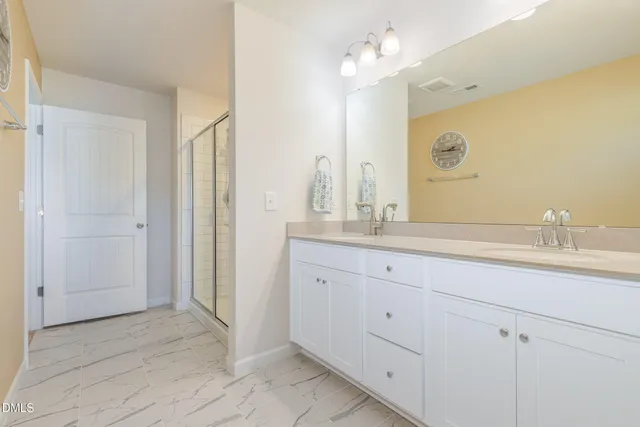 a bathroom with double sink and a mirror