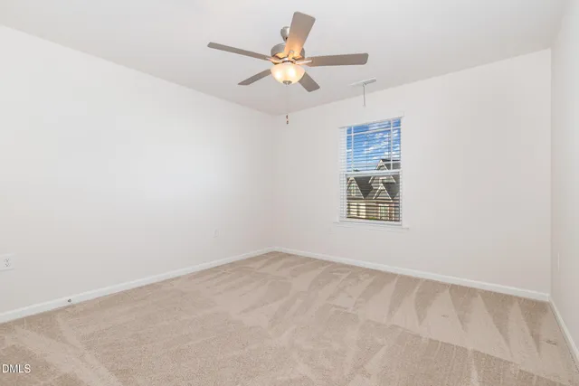 an empty room with a window and a ceiling fan