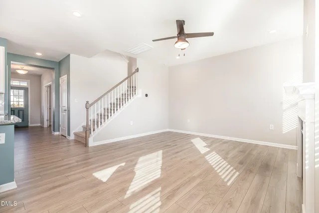 a view of a livingroom with wooden floor and staircase