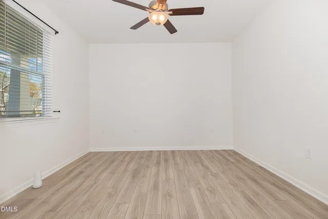 a view of a room with wooden floor and a ceiling fan