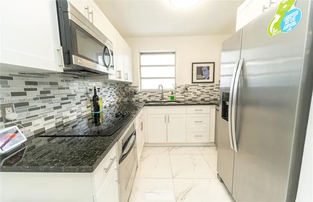 a kitchen with stainless steel appliances granite countertop a sink and a stove