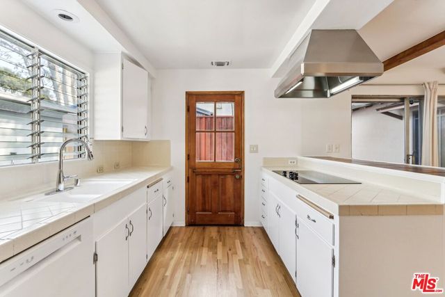 a spacious bathroom with a granite countertop sink a mirror and a bathtub