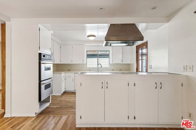 a kitchen with granite countertop white cabinets and white appliances