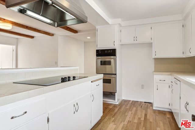 a kitchen with granite countertop a stove a sink and a refrigerator