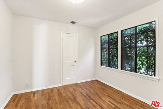 a view of a room with wooden floor and a window