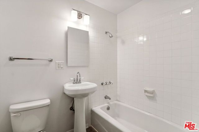 a view of a backyard with potted plants and large trees