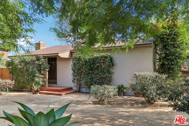 a view of a house with pool and plants