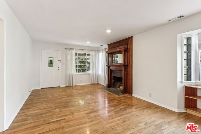 a view of an empty room with window and fire place