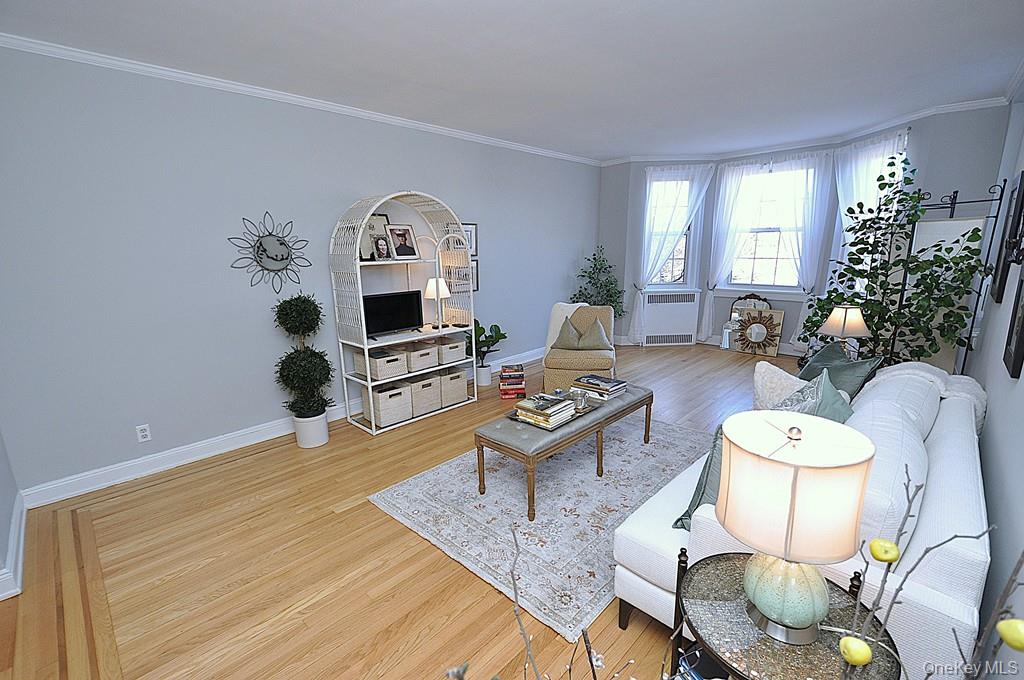 253 Garth Road, Unit 6J Scarsdale, NY 10583 - Photo 6 of 41 Oversized living room has a bay window, stunning hardwood floors and opens to the dining room. The living room is approx 22'-3" x 12'-8"