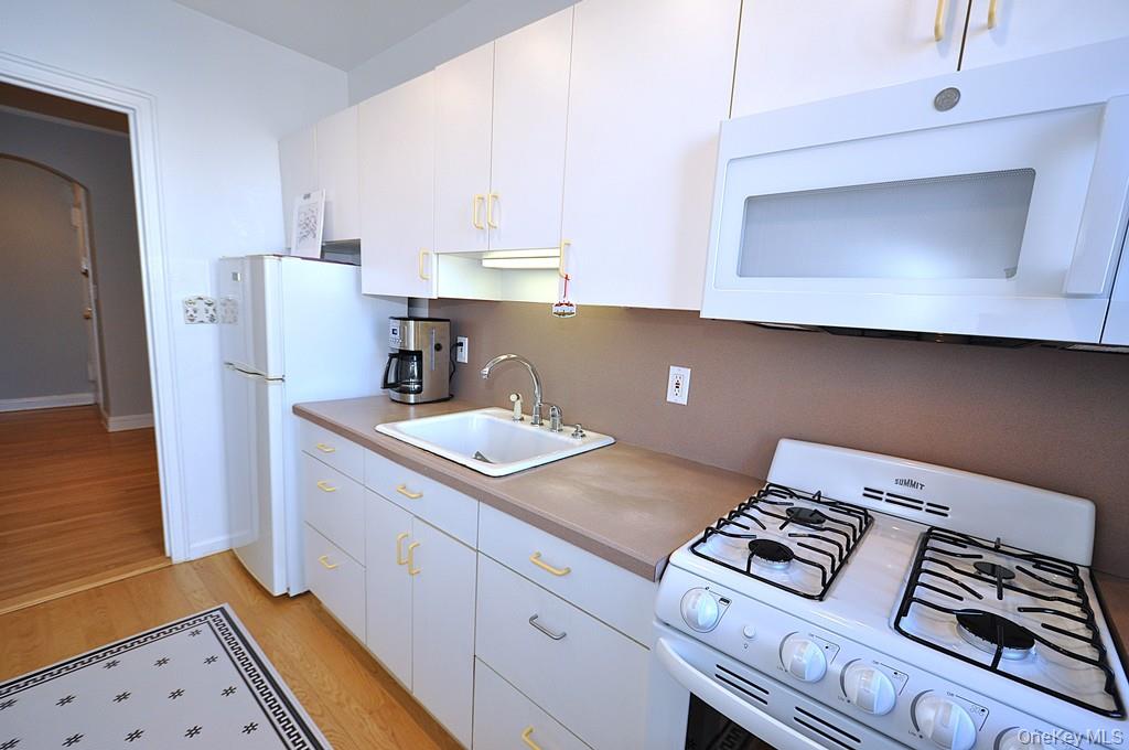 253 Garth Road, Unit 6J Scarsdale, NY 10583 - Photo 10 of 41 Kitchen has a range, microwave, refrigerator and a window for ventilation and natural light.