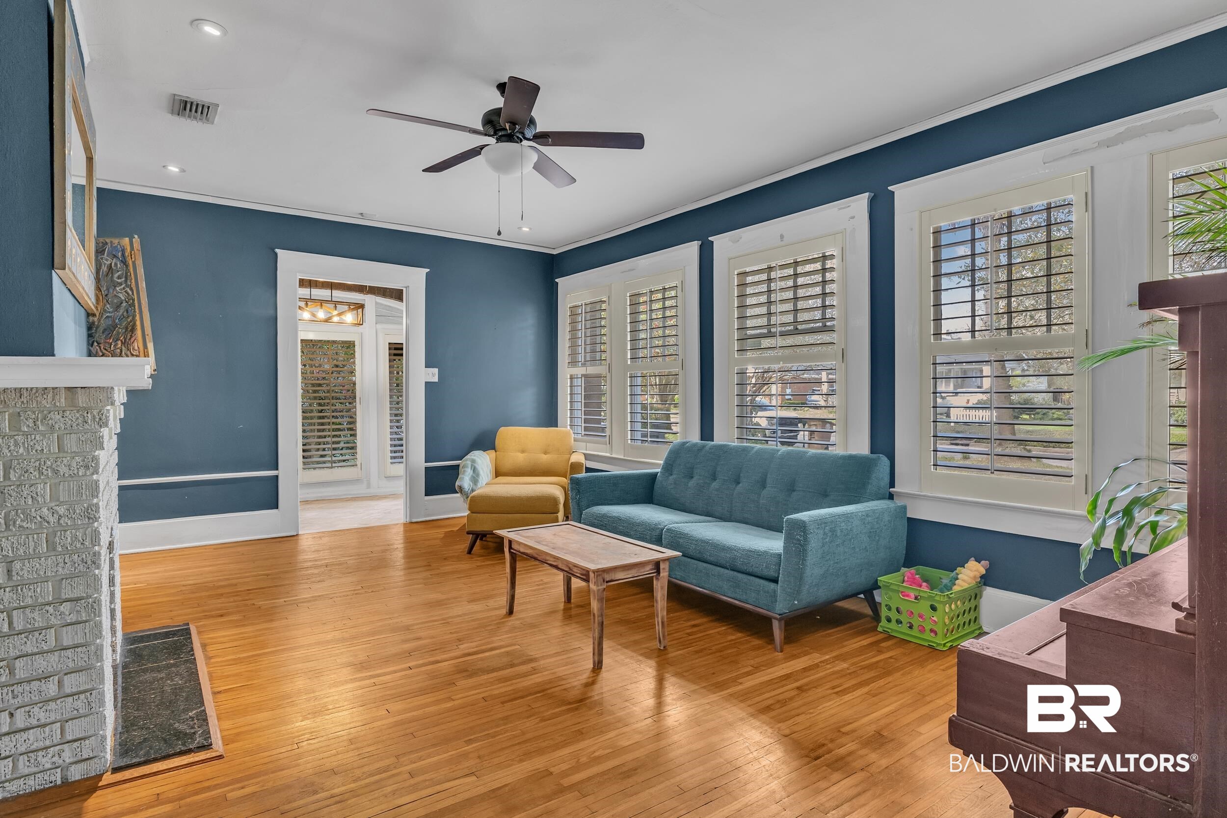 55 Mohawk Street Mobile, AL 36606 - Photo 11 of 28 Living area with visible vents, baseboards, ornamental molding, wood finished floors, and a ceiling fan