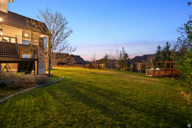 1205 North Elk Rdg Lane, Unit 202 Alpine, UT 84004 - Photo 87 of 88 Expansive lawn area featuring a multi-level deck with black railings, a stone chimney, and a wooden hot tub deck with an overhead pergola structure