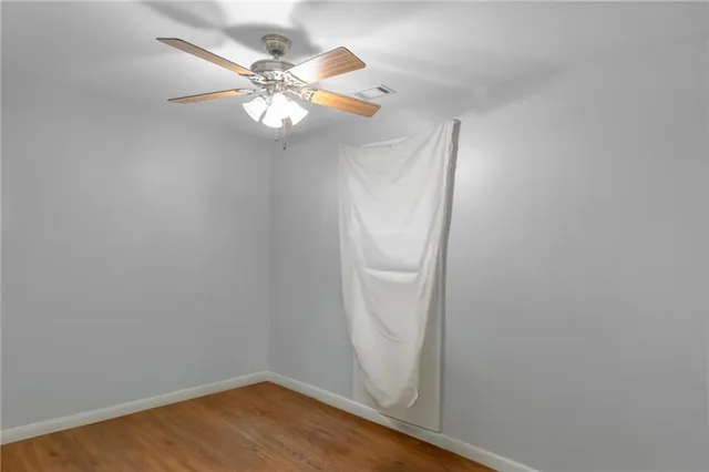 a view of a small space with wooden floor and a fan