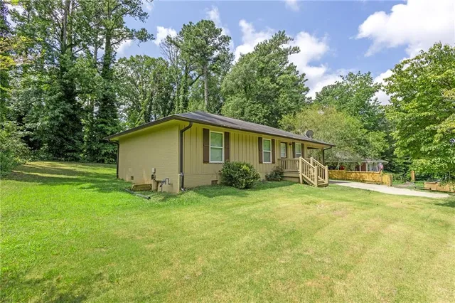 a view of a house with backyard and trees