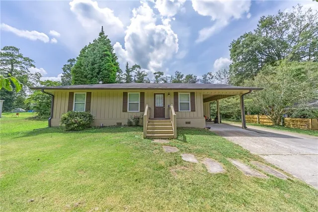 a view of a house with a backyard and a patio
