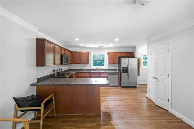 a kitchen with stainless steel appliances granite countertop a sink refrigerator and cabinets
