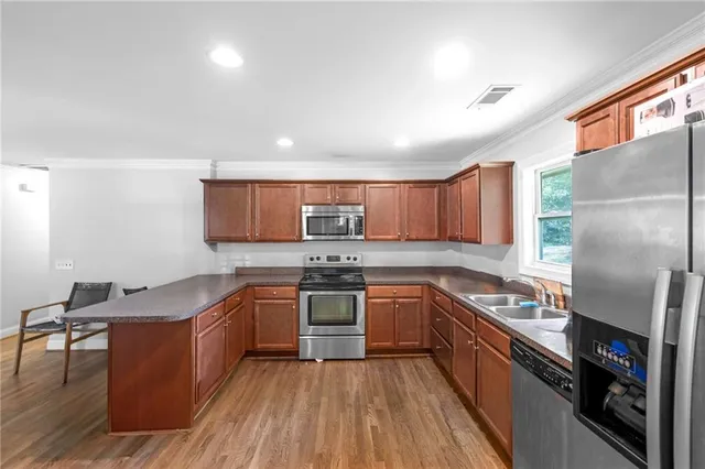 a kitchen with stainless steel appliances granite countertop a stove a sink dishwasher and a refrigerator