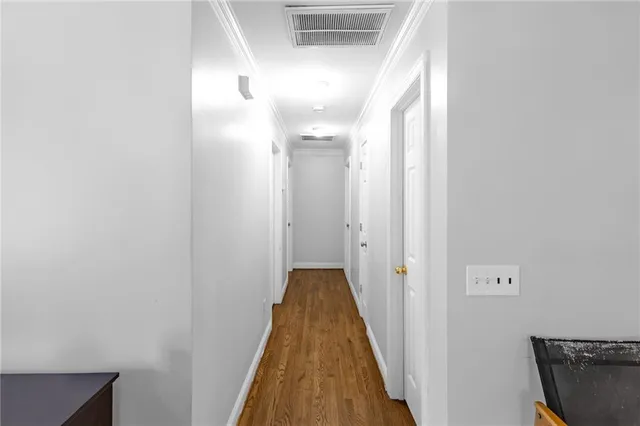 a view of a hallway with wooden floor and staircase