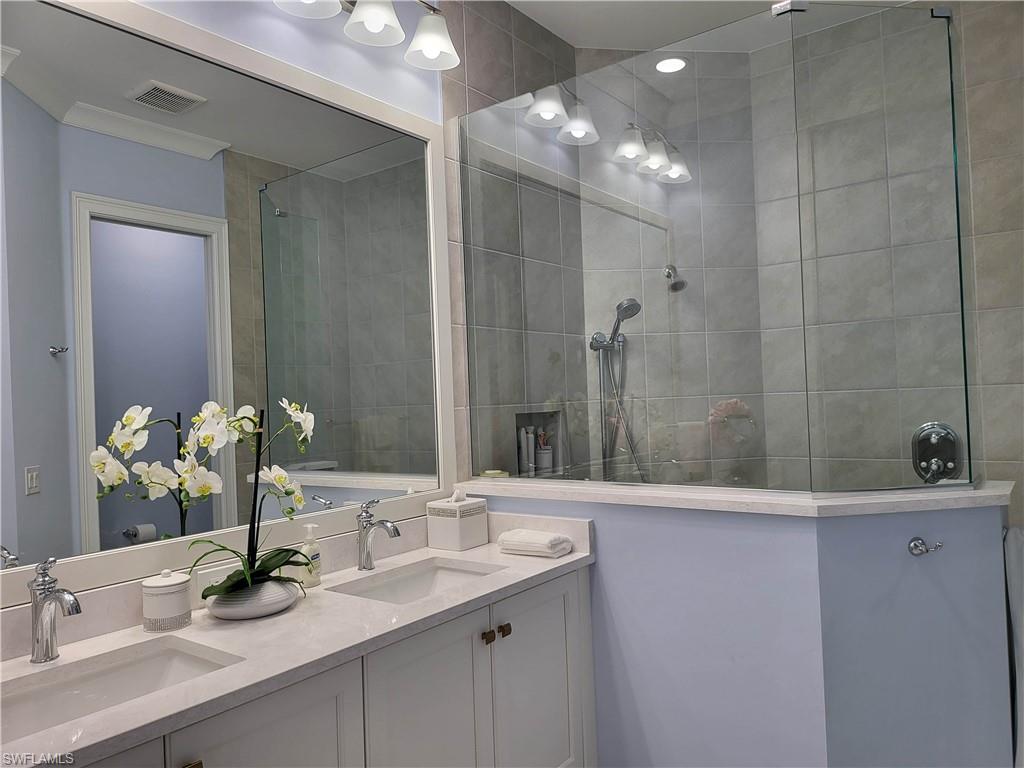 8920 Calypso Court Naples, FL 34113 - Photo 12 of 41 a bathroom with a double vanity sink and a mirror
