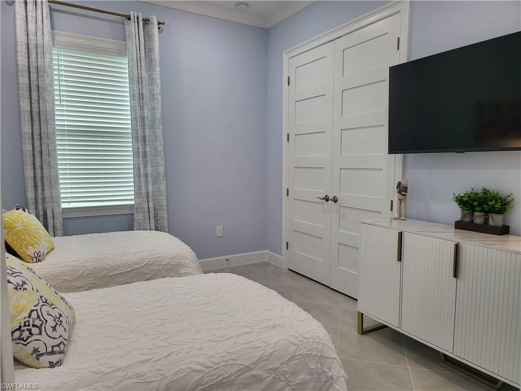 8920 Calypso Court Naples, FL 34113 - Photo 13 of 41 a bedroom with a bed and a flat screen tv