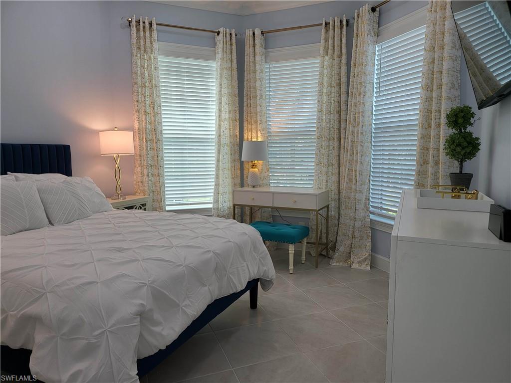 8920 Calypso Court Naples, FL 34113 - Photo 16 of 41 a bedroom with a bed and a table