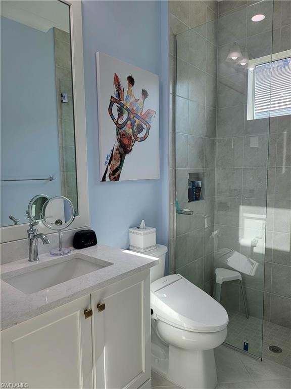 8920 Calypso Court Naples, FL 34113 - Photo 18 of 41 a bathroom with a toilet sink and mirror