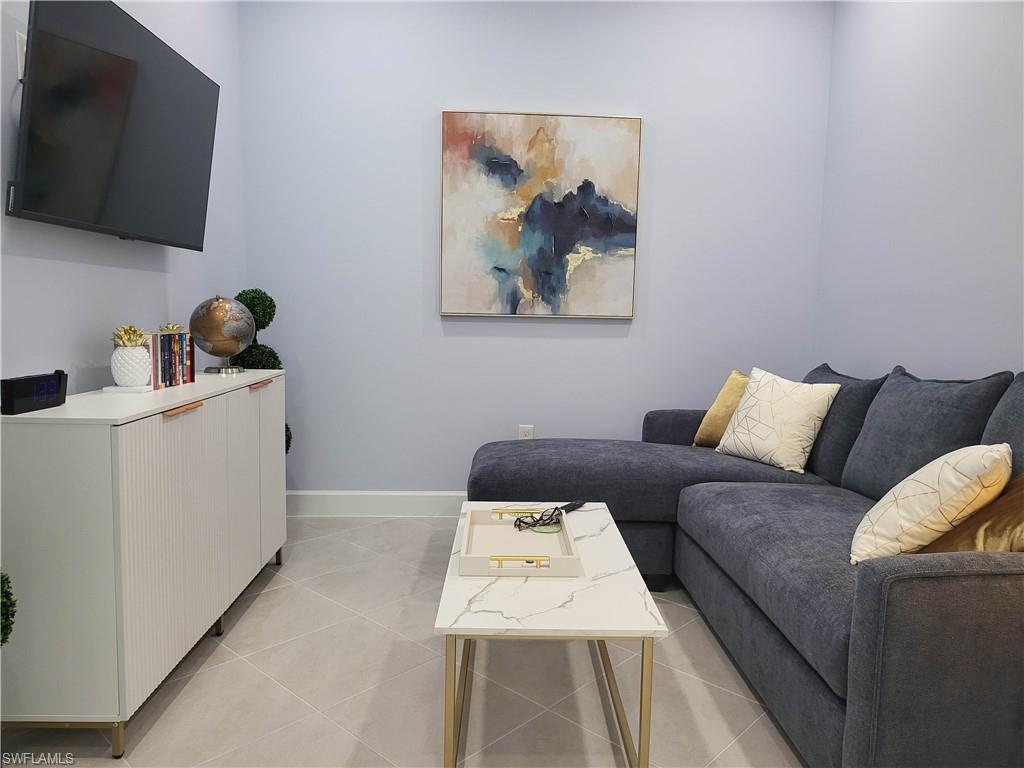 8920 Calypso Court Naples, FL 34113 - Photo 19 of 41 a living room with furniture and a flat screen tv