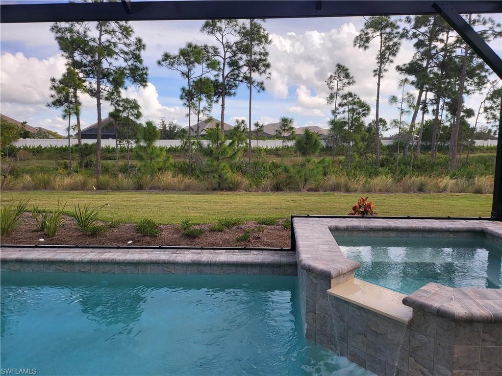 8920 Calypso Court Naples, FL 34113 - Photo 5 of 41 a view of a lake with a yard and large trees