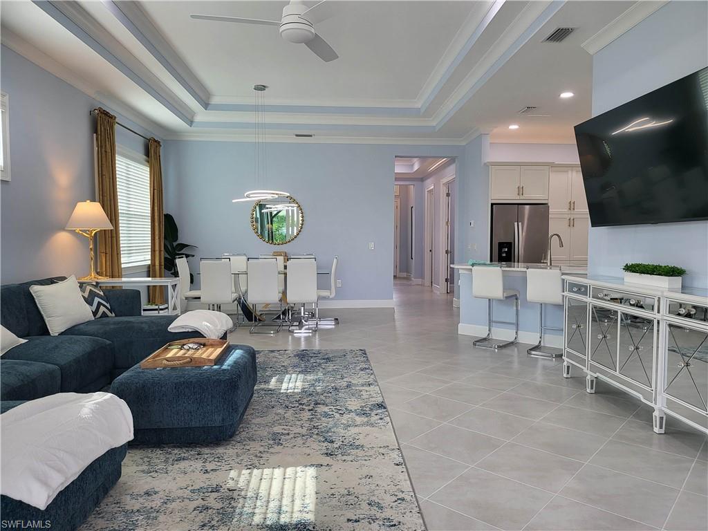 8920 Calypso Court Naples, FL 34113 - Photo 7 of 41 a living room with furniture and a flat screen tv