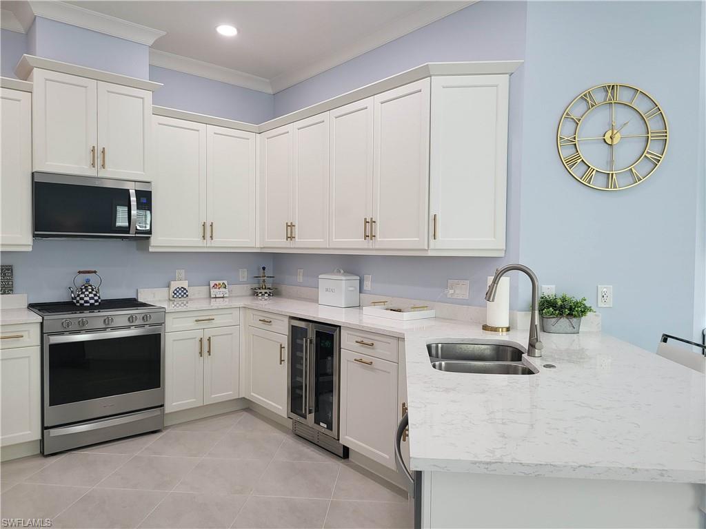 8920 Calypso Court Naples, FL 34113 - Photo 9 of 41 a kitchen with a stove and a microwave