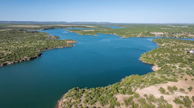 a kitchen with stainless steel appliances granite countertop a stove top oven a sink a dining table and chairs