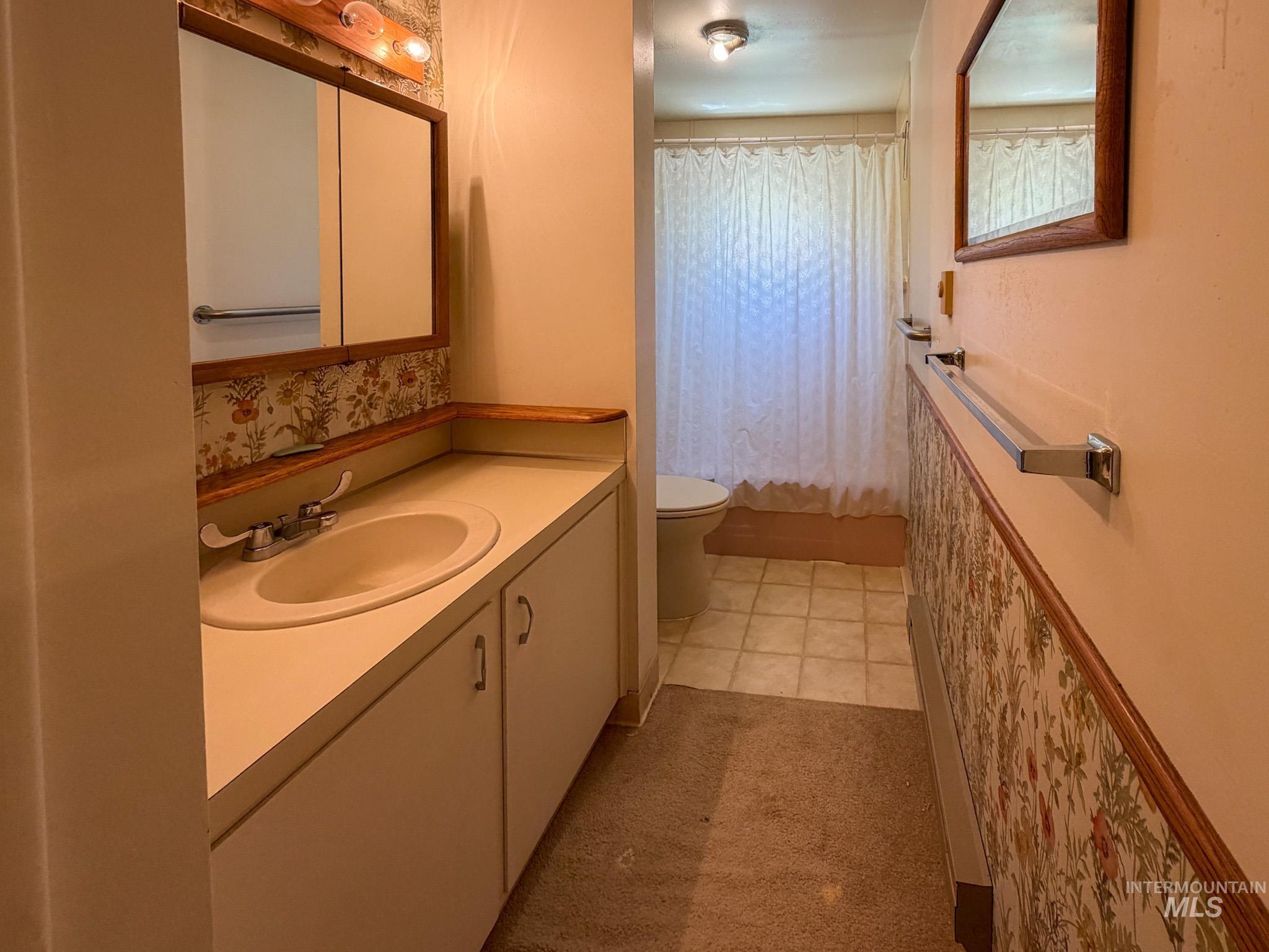 1924 H Street Rupert, ID 83350 - Photo 7 of 13 Bathroom featuring a vanity with an integrated sink, medicine cabinet with mirrored doors, and a full-size tub/shower combination