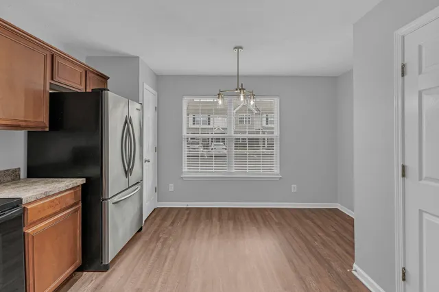 a kitchen with stainless steel appliances a refrigerator and a hard wood floor